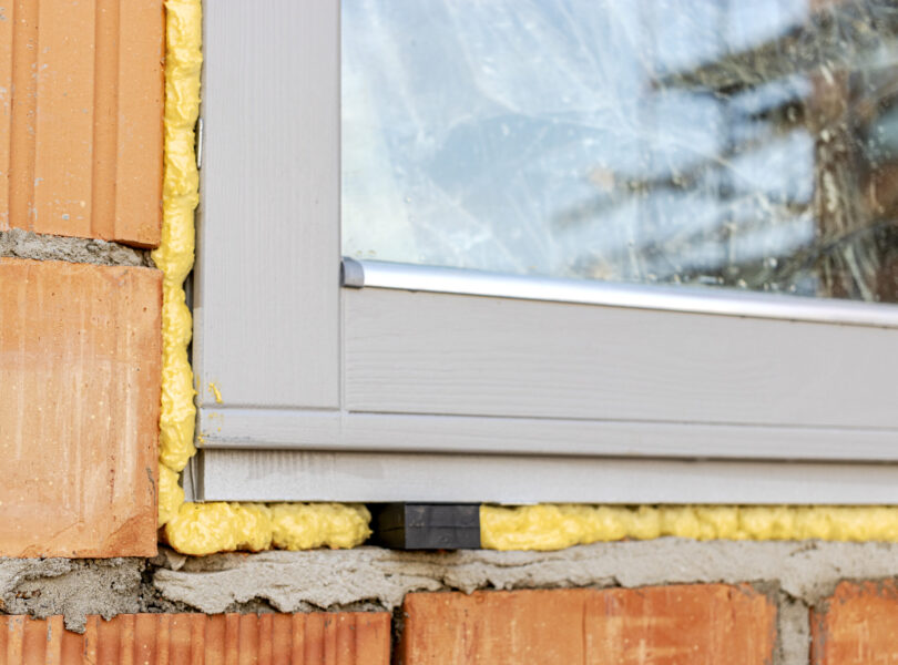 Installation of a window in a brick building. Industrial engineering. Darkening and installation of a window opening using polyurethane foam.