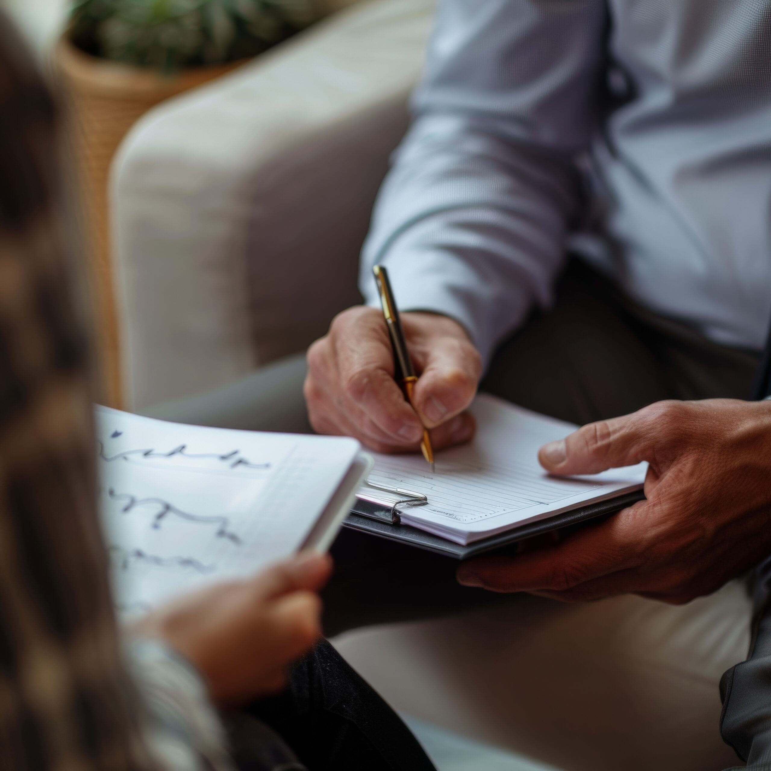 Two people discussing notes in a professional setting, emphasizing collaborative brainstorming and detailed documentation.